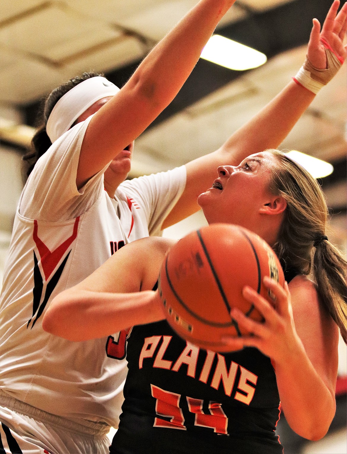 MCKENNZIE CANNON (34) from Hot Springs, blocks a shot from Genna Deschamps (24) from Plains, during last Friday&#146;s game. (John Dowd/Clark Fork Valley Press)