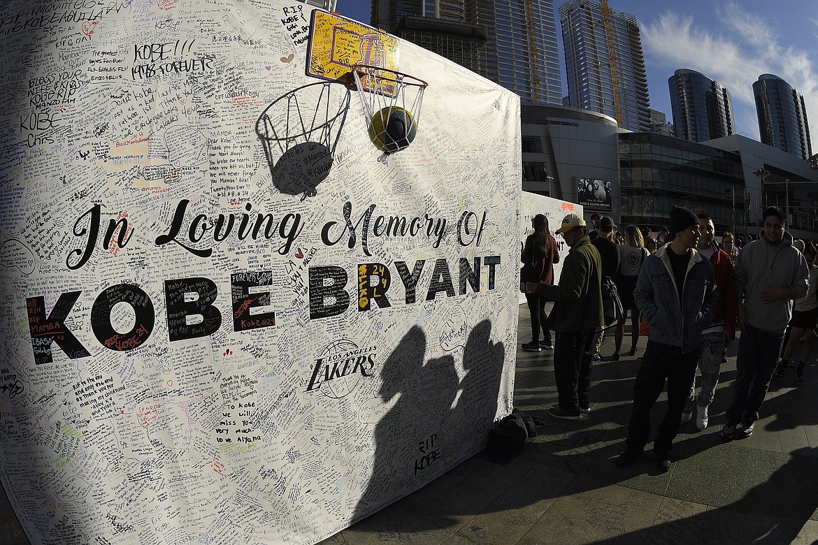 MARK J. TERRILL/Associated Press
Shadows are cast on a memorial wall as fans gather at LA Live, near Staples Center where the Los Angeles Lakers play, to memorialize Kobe Bryant on Tuesday in Los Angeles following a helicopter crash Sunday that killed the former NBA basketball player, his 13-year-old daughter, Gianna, and seven others.