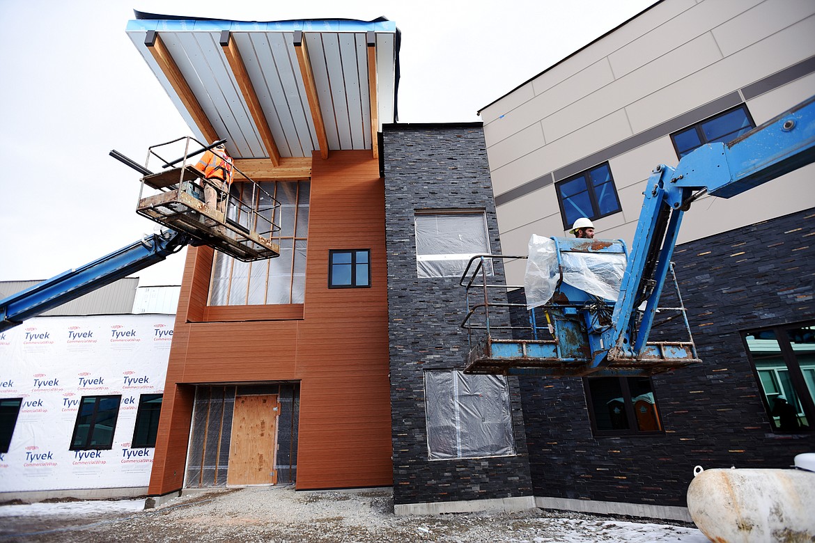 Workers on boom lifts work on the facade of the Somers Middle School construction project on Wednesday, Jan. 22. The new building is slated for completion in the spring and will open for the next school year. (Casey Kreider/Daily Inter Lake)