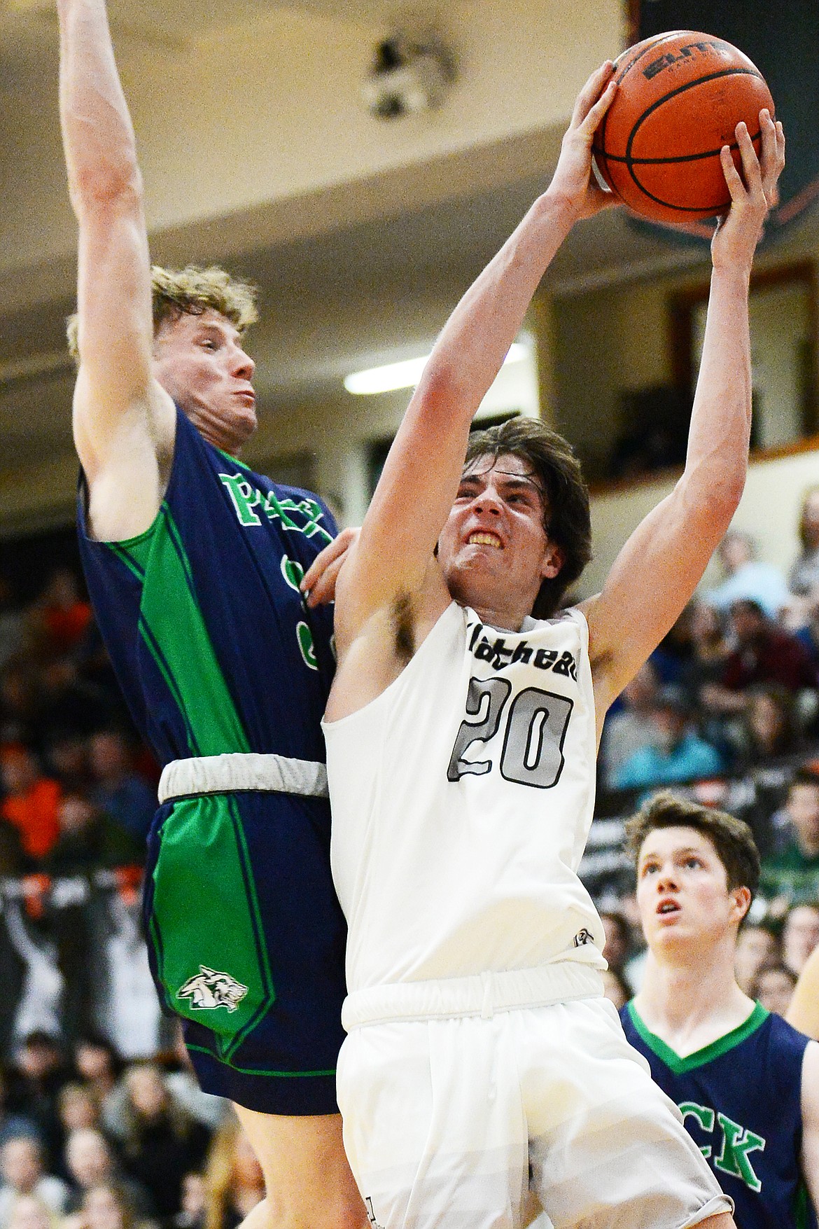 Flathead's Cooper Smith (20) drives to the hoop guarded by Glacier's Colin Presnell (33) in the second half during a crosstown matchup at Flathead High School on Friday. (Casey Kreider/Daily Inter Lake)