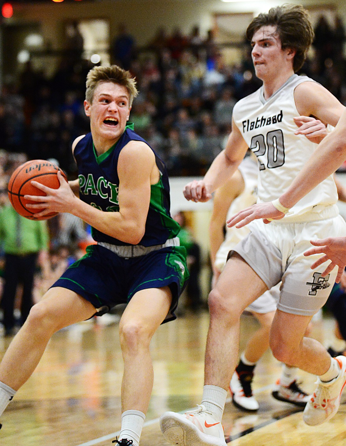 Glacier's Michael Schwarz (22) looks to pass guarded by Flathead's Cooper Smith (20) in the first half during a crosstown matchup at Flathead High School on Friday. (Casey Kreider/Daily Inter Lake)