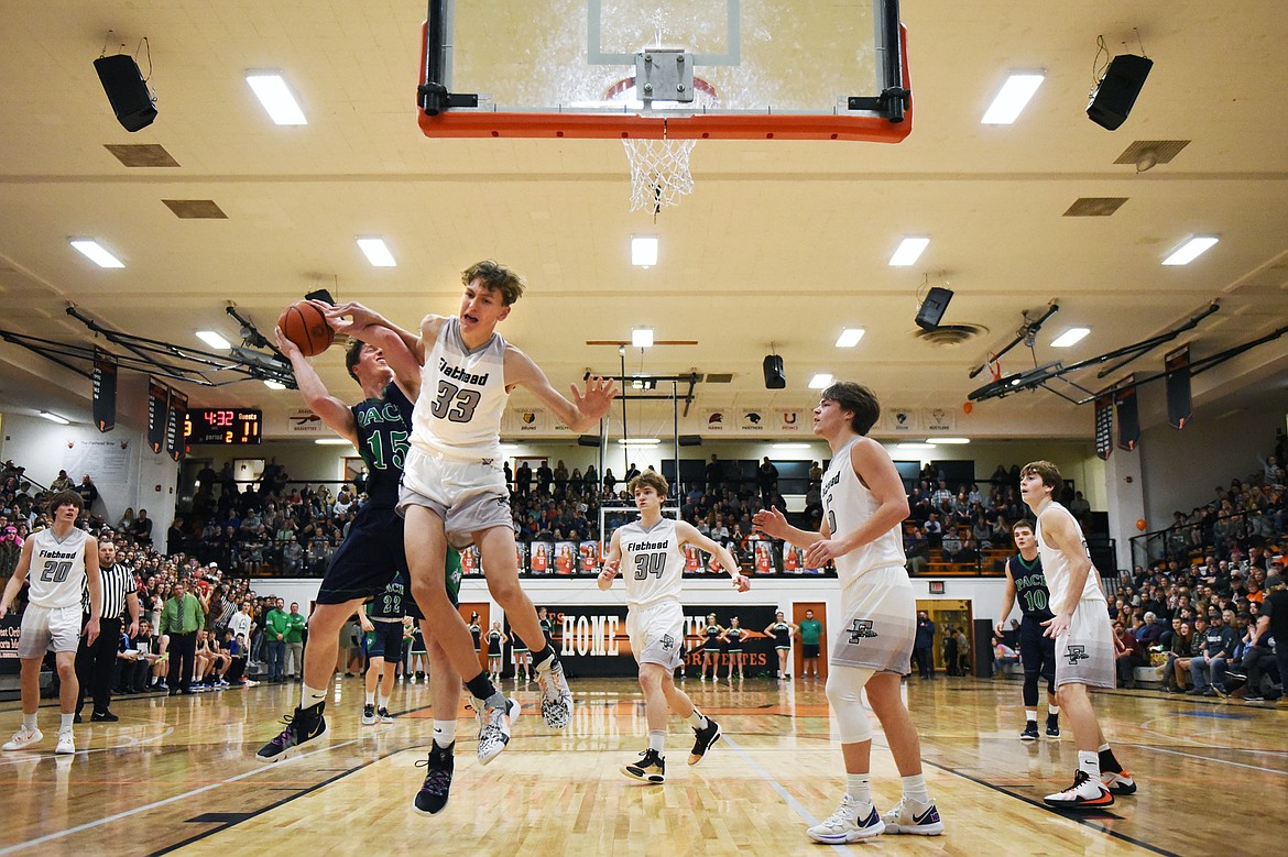 Glacier's Drew Engellant (15) is fouled on his way to the hoop by Flathead's Ezra Epperly (33) in the first half during a crosstown matchup at Flathead High School on Friday. (Casey Kreider/Daily Inter Lake)