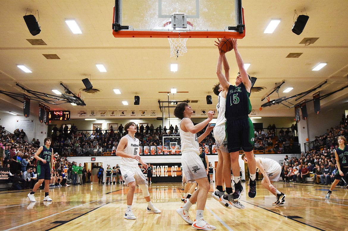 Glacier's Drew Engellant (15) drives to the hoop guarded by Flathead's Ezra Epperly (33) in the first half during a crosstown matchup at Flathead High School on Friday. (Casey Kreider/Daily Inter Lake)