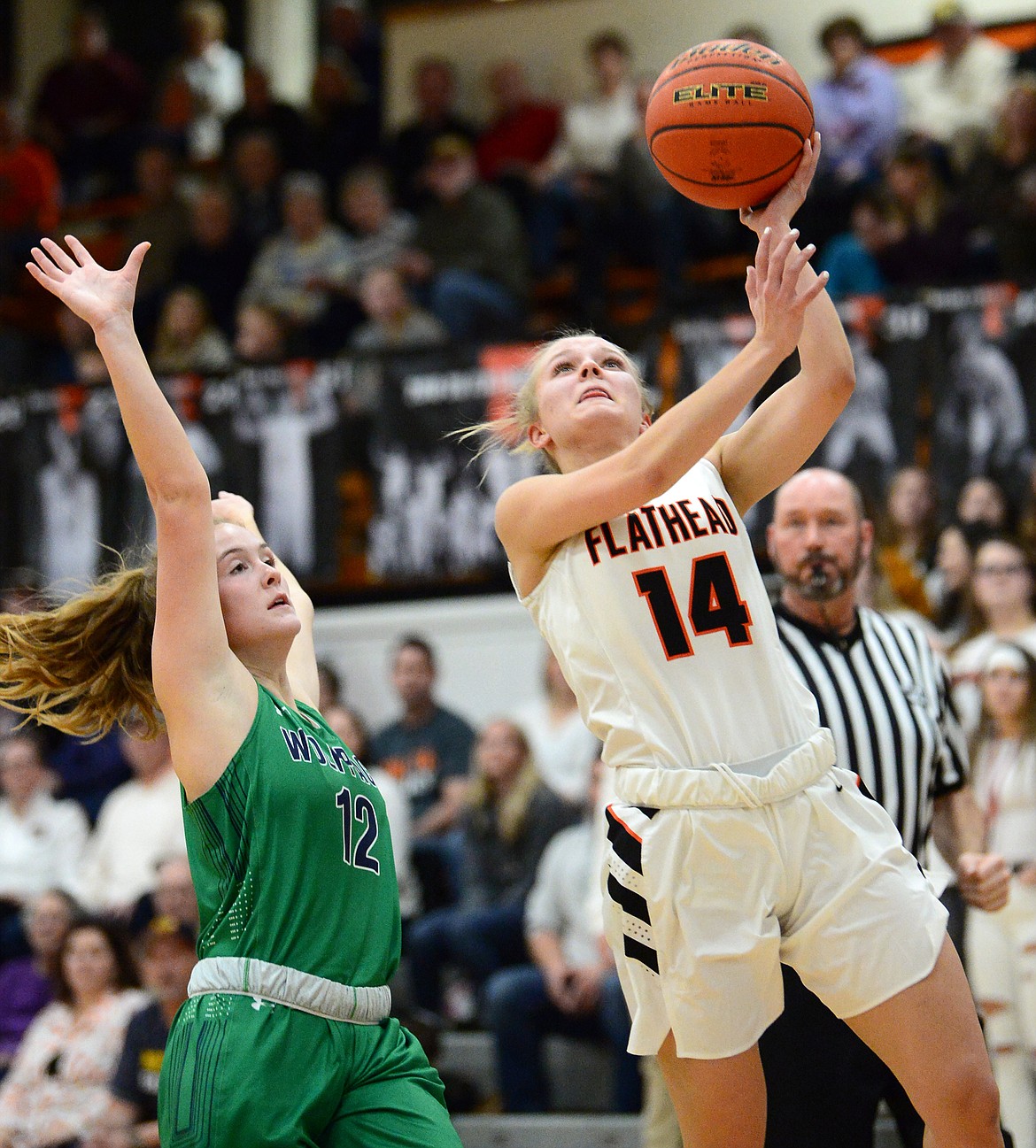 Flathead's Jenna Johnson (14) drives to the basket past Glacier's Kenzie Williams (12) during a crosstown matchup with Glacier at Flathead High School on Thursday. (Casey Kreider/Daily Inter Lake)