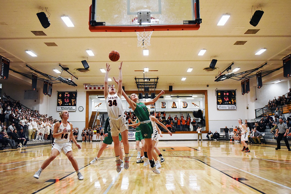 Flathead's Molly Winters (34) and Glacier's Aubrie Rademacher (14) battle for a rebound in the final seconds of the fourth quarter during a 51-49 Wolfpack win at Flathead High School on Thursday. (Casey Kreider/Daily Inter Lake)