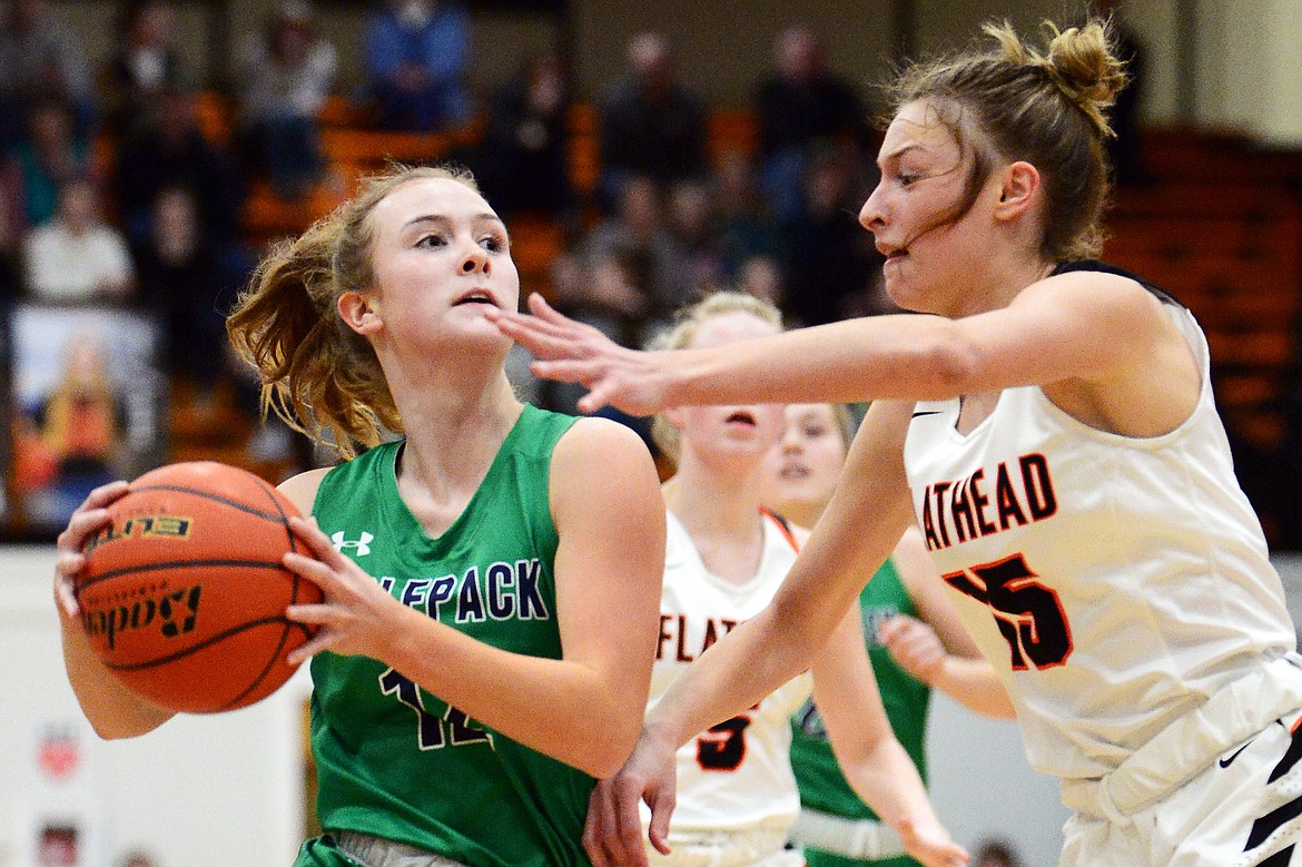 Glacier's Kenzie Williams (12) drives to the basket guarded by Flathead's Clare Converse (15) in the first half during a crosstown matchup at Flathead High School on Thursday. (Casey Kreider/Daily Inter Lake)