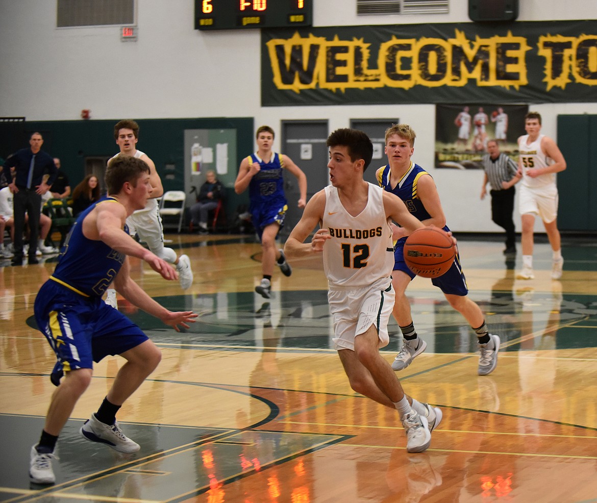 Whitefish senior Daniel Davis dribbles around the Logger defense Friday night at the Whitefish High School gym. (Heidi Desch/Whitefish Pilot)