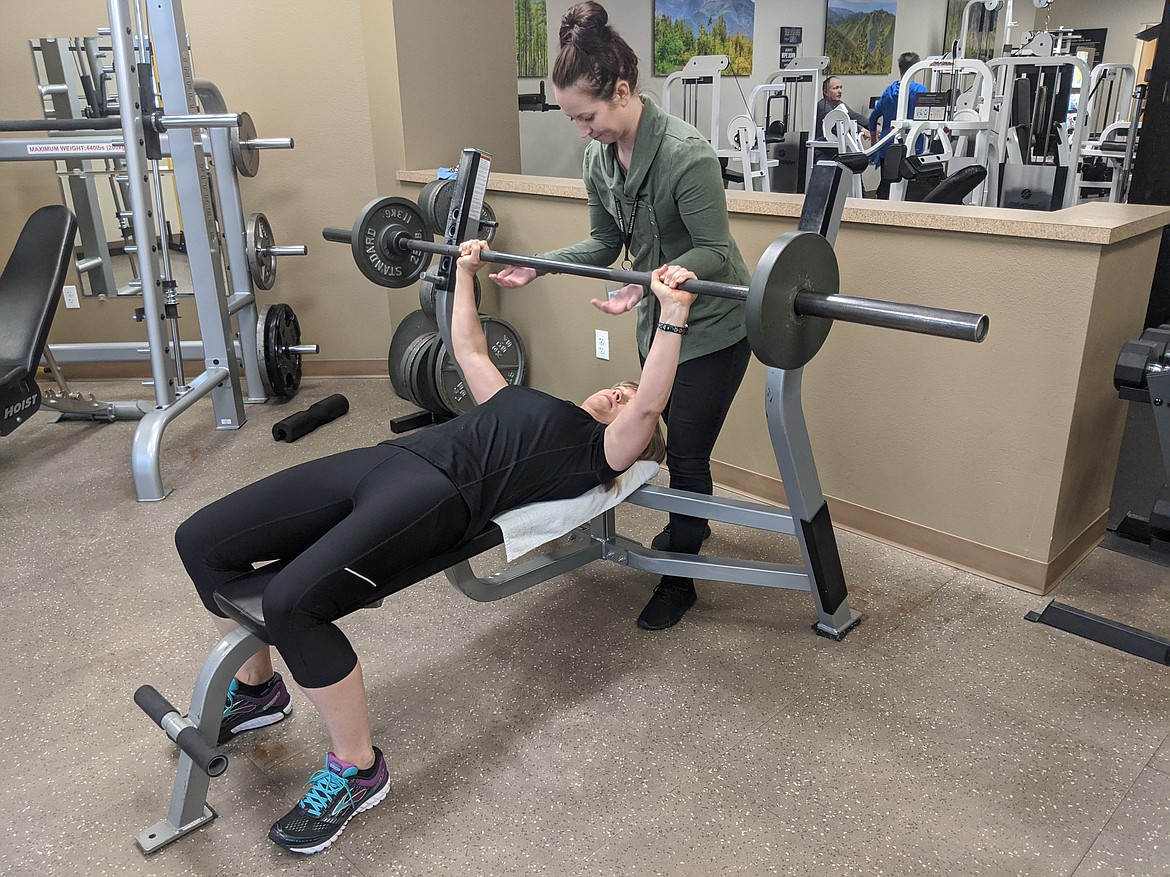 Wellness Center Manager Jonnie Nosworthy assists Sheri Zumstein with bench presses. Nosworthy and Zumstein will have friendly competitions together during classes to motivate one another.
Photo by
CHANSE WATSON