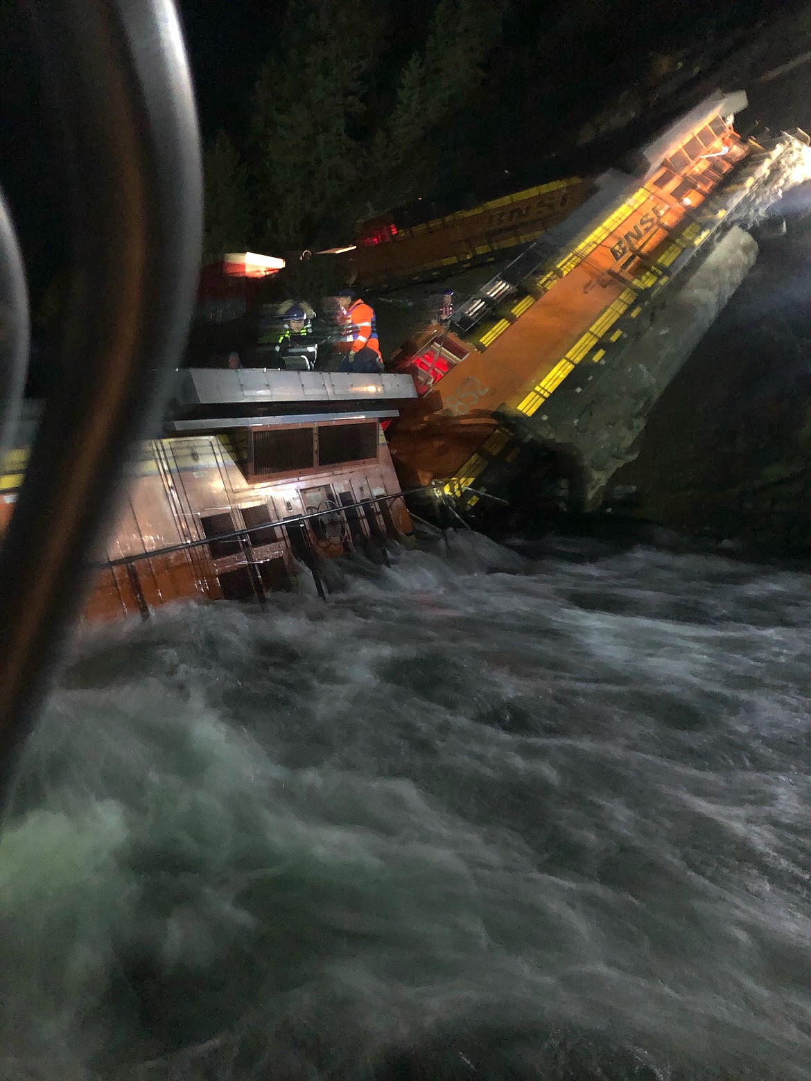 Courtesy photo 
Boundary County Search and Dive Rescue Team member Adam Reeves is seen on top of the locomotive with the two Burlington Northern Santa Fe crew members waiting for rescue, as Marine 1 negotiates the rushing water to reach to the train. Reeves, who also is a BNSF railroad employee, was honored for his actions during the Jan. 1 derailment of a BNSF train which fell into the Kootenai River.