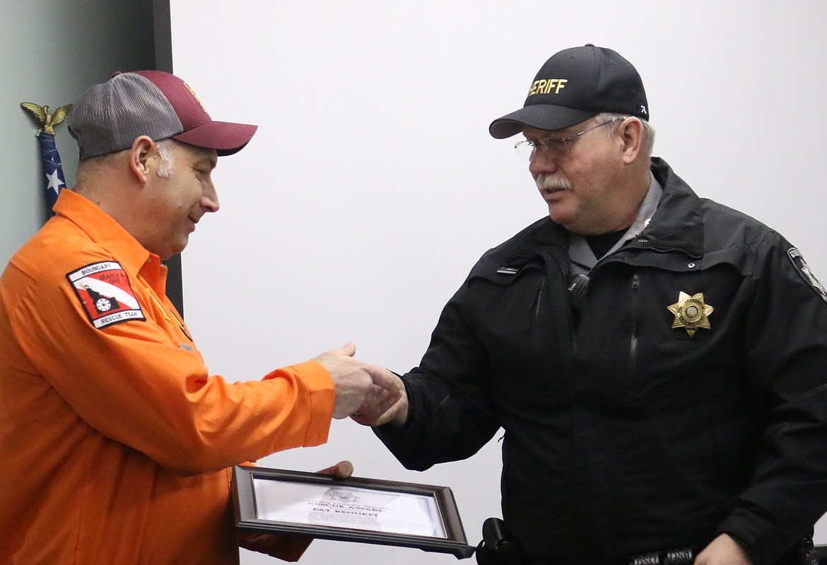 Photo by MANDI BATEMAN 
Boundary Search and Dive Rescue Team Vice Commander Pat Bennett receives a rescue award and Sheriff&#146;s Office challenge coin from Boundary County Sheriff Dave Kramer.