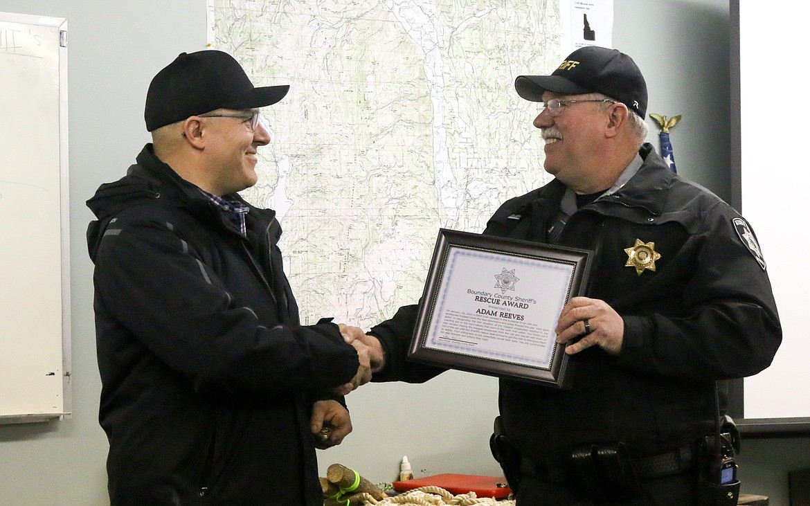 Photo by MANDI BATEMAN 
Boundary Search and Dive Rescue Team member and BNSF employee, Adam Reeves, receives a rescue award and Sheriff&#146;s Office challenge coin from Boundary County Sheriff Dave Kramer.