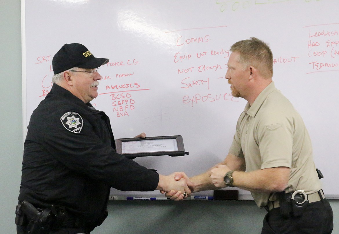 Photo by MANDI BATEMAN 
Boundary County Sheriff&#146;s Detective Caleb Watts receives a rescue award and Sheriff&#146;s Office challenge coin from Boundary County Sheriff Dave Kramer.