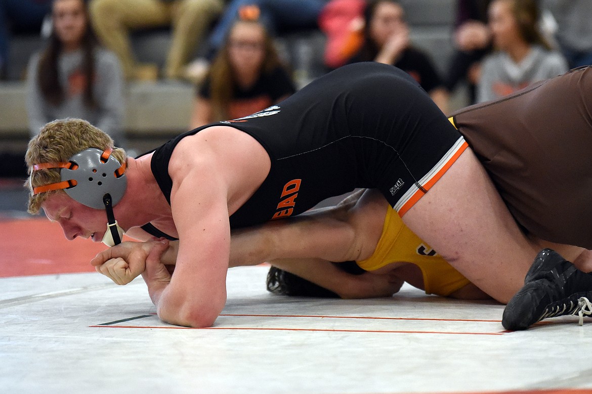 Flathead's Zaybin Stewart works toward a pin of Helena Capital's Keaton Pouliot at 205 lbs. at Flathead High School on Thursday. (Casey Kreider/Daily Inter Lake)