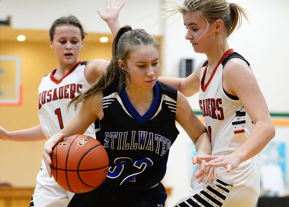 Stillwater Christian's Emma Linn (32) looks to dribble around the defense of Flathead Valley Home School's Corey Connerly at Kalispell Middle School on Saturday. (Casey Kreider/Daily Inter Lake)