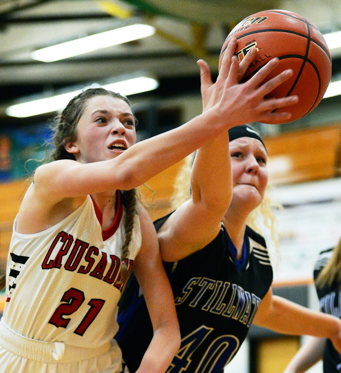 Flathead Valley Home School's Abby Wiser (21) and Stillwater Christian's Selah Neumann (40) battle for a loose ball at Kalispell Middle School on Saturday. (Casey Kreider/Daily Inter Lake)