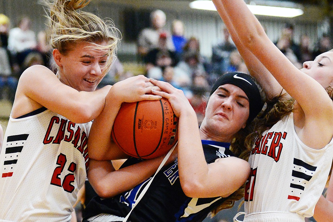 Stillwater Christian's Madison Morken (24) fights for a loose ball with Flathead Valley Home School's Corey Connerly (22) and Abby Wiser (21) at Kalispell Middle School on Saturday. (Casey Kreider/Daily Inter Lake)