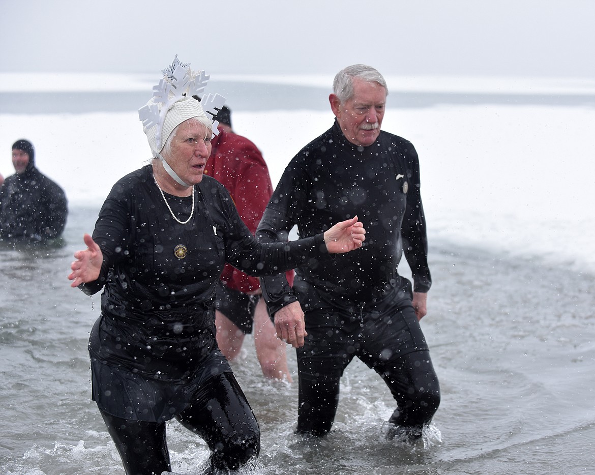 Queen of Snows Gayle MacLaren and King Ullr Scotty MacLaren emerge from Whitefish Lake Saturday morning during the annual Penguin Plunge at City Beach. The event raises money for Special Olympics Montana. (Heidi Desch/Whitefish Pilot)