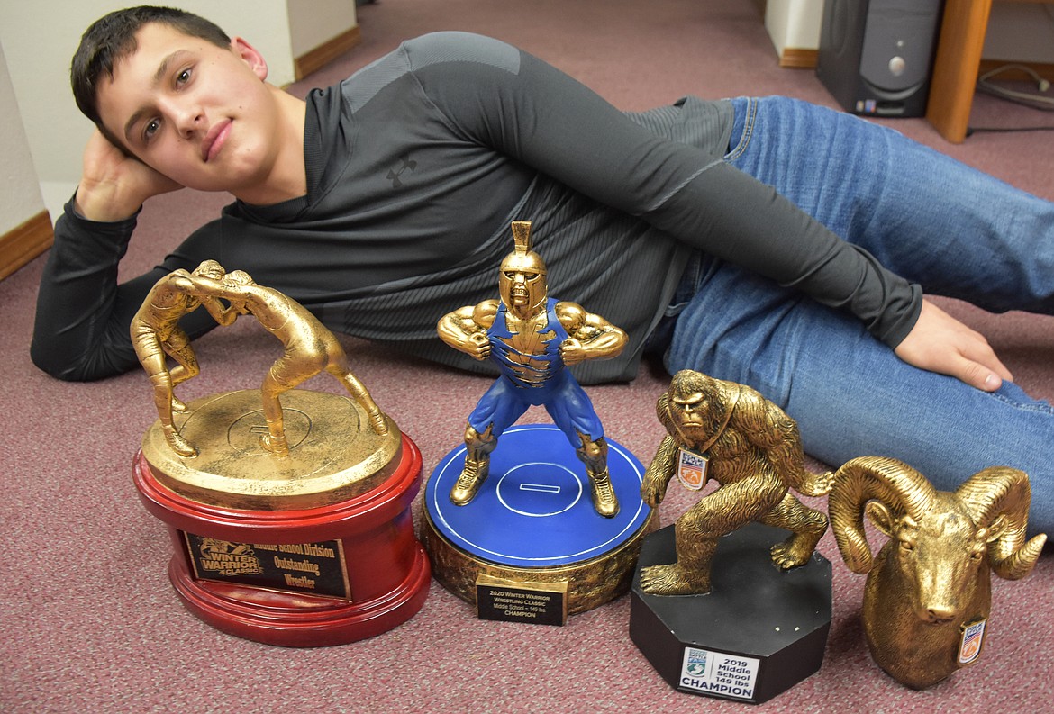 Jace DeShazer, 14, poses with a few of the trophies he has won wrestling in recent years. The Libby native and eighth grader wrestles at 149 pounds. (Duncan Adams/The Western News)