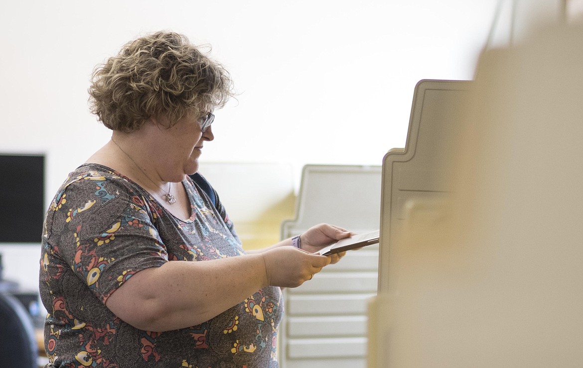 Deanna Malyevac reads over a mill levy ballot -- a tax which would help fund a Student Resource Officer for the Libby Public School -- before turning in her vote, Tuesday in the school's administration building. (Luke Hollister/The Western News)