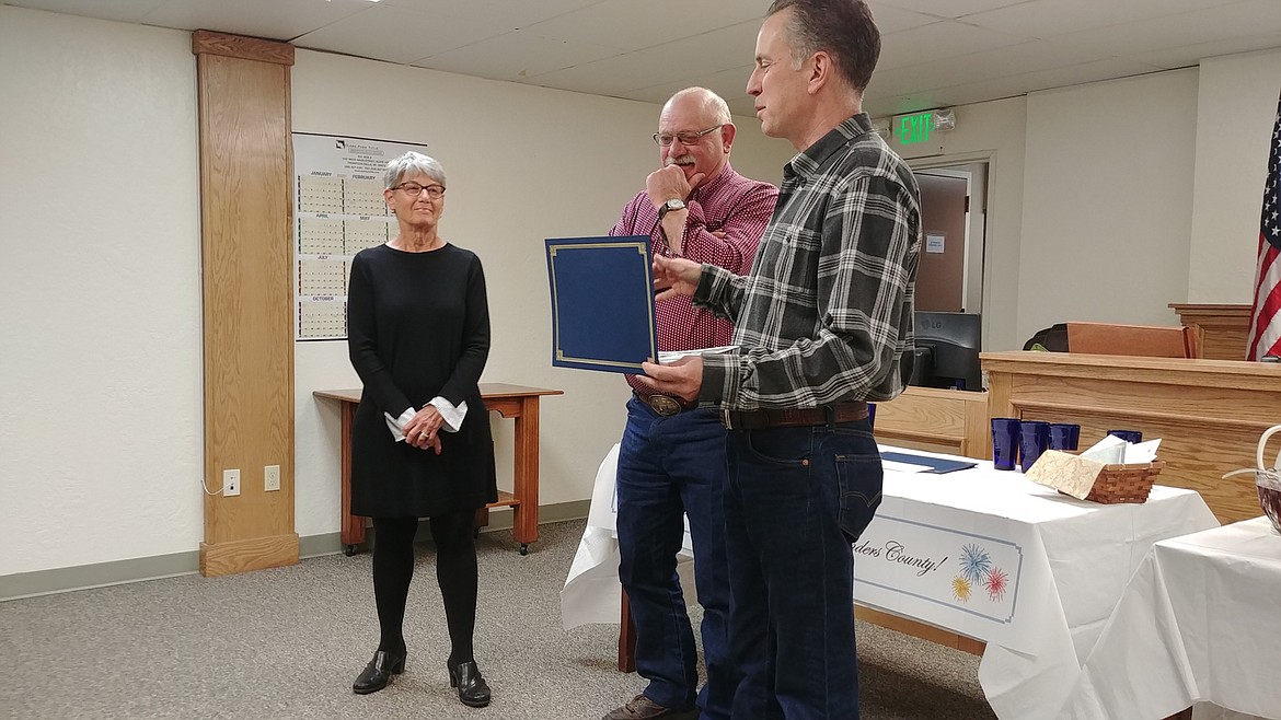 Sanders County commissioners Tony Cox, right, and Glen Magera, middle, present a 25-year service award to fellow commissioner Carol Brooker at the county awards ceremony in Thompson Falls. (Chuck Bandel/Valley Press)