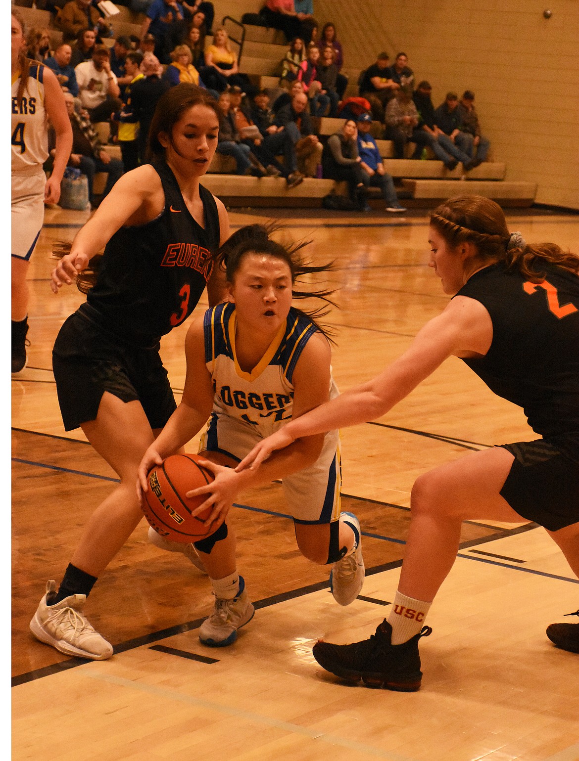 Syd Gier fights through two Eureka defenders during the Battle of the Kootenai last week. Though the Lady Loggers fell 36-27, they still came away as overall champs. (Duncan Adams/The Western News)