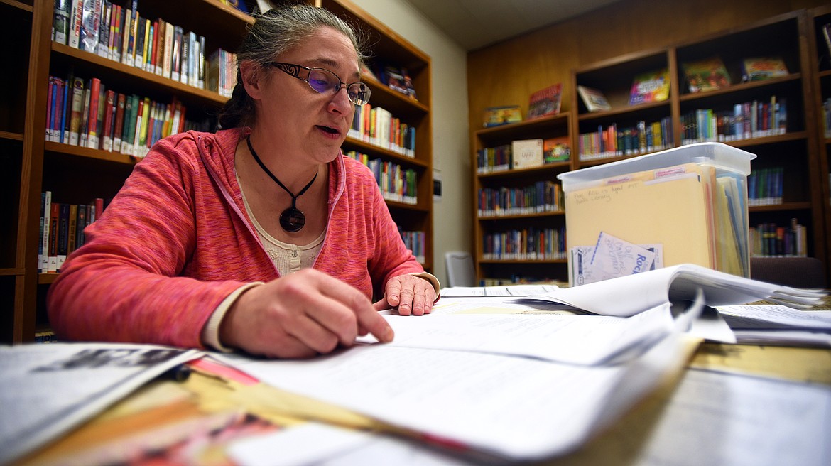 Ronan Library District Director Michelle Fenger looks through the purchase documents for the library building from 1971 and 2001. (Jeremy Weber/Daily Inter Lake)