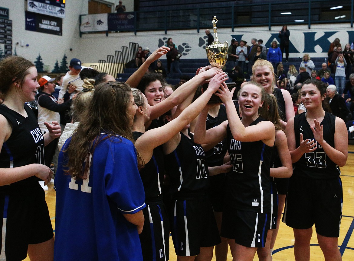 The Coeur d&#146;Alene Vikings celebrate their 58-36 win over the Lake City Timberwolves for the Region 1 championship trophy Wednesday at Lake City. (LOREN BENOIT/Press)