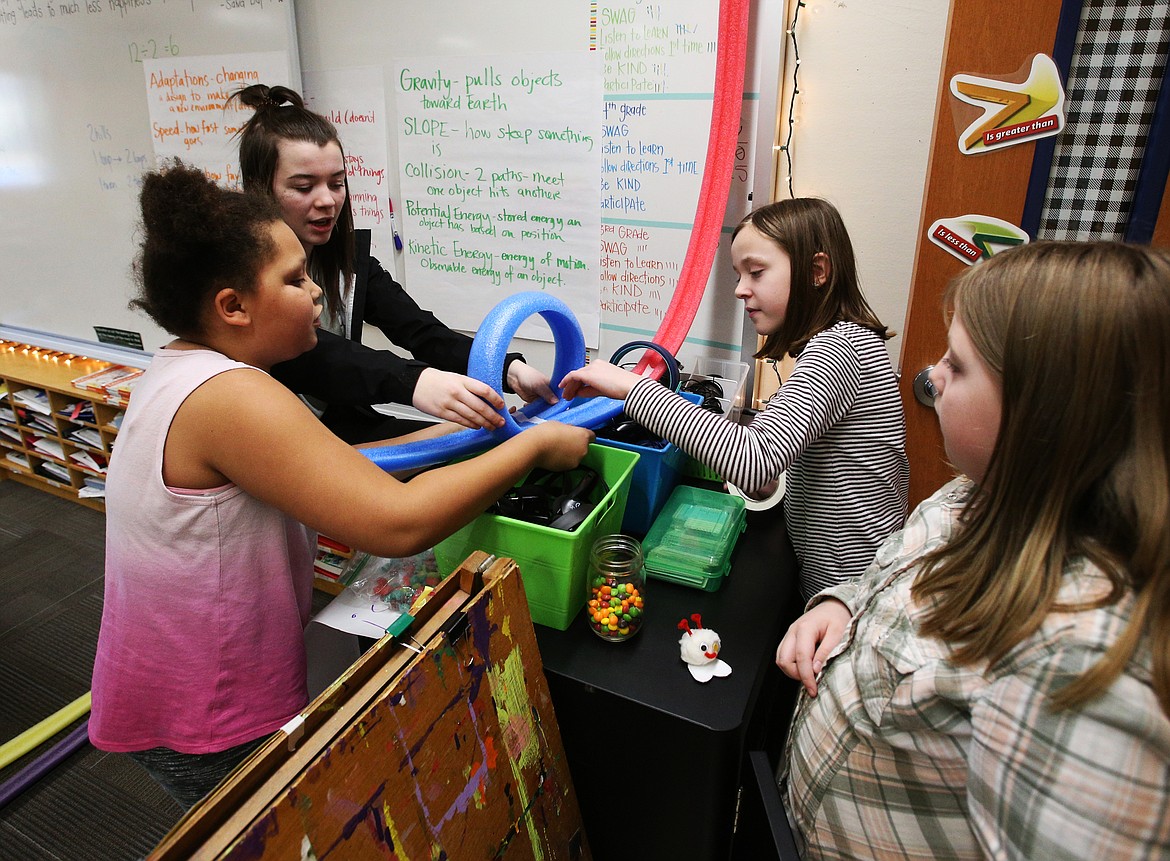 Coeur d'Alene High School freshman Saray Goode, second left, helps Borah students Taliyah Campbell, left, Trinity Price, far right, and Danica Martzall make a roller coaster during STEM club after school on Monday. (LOREN BENOIT/Press)