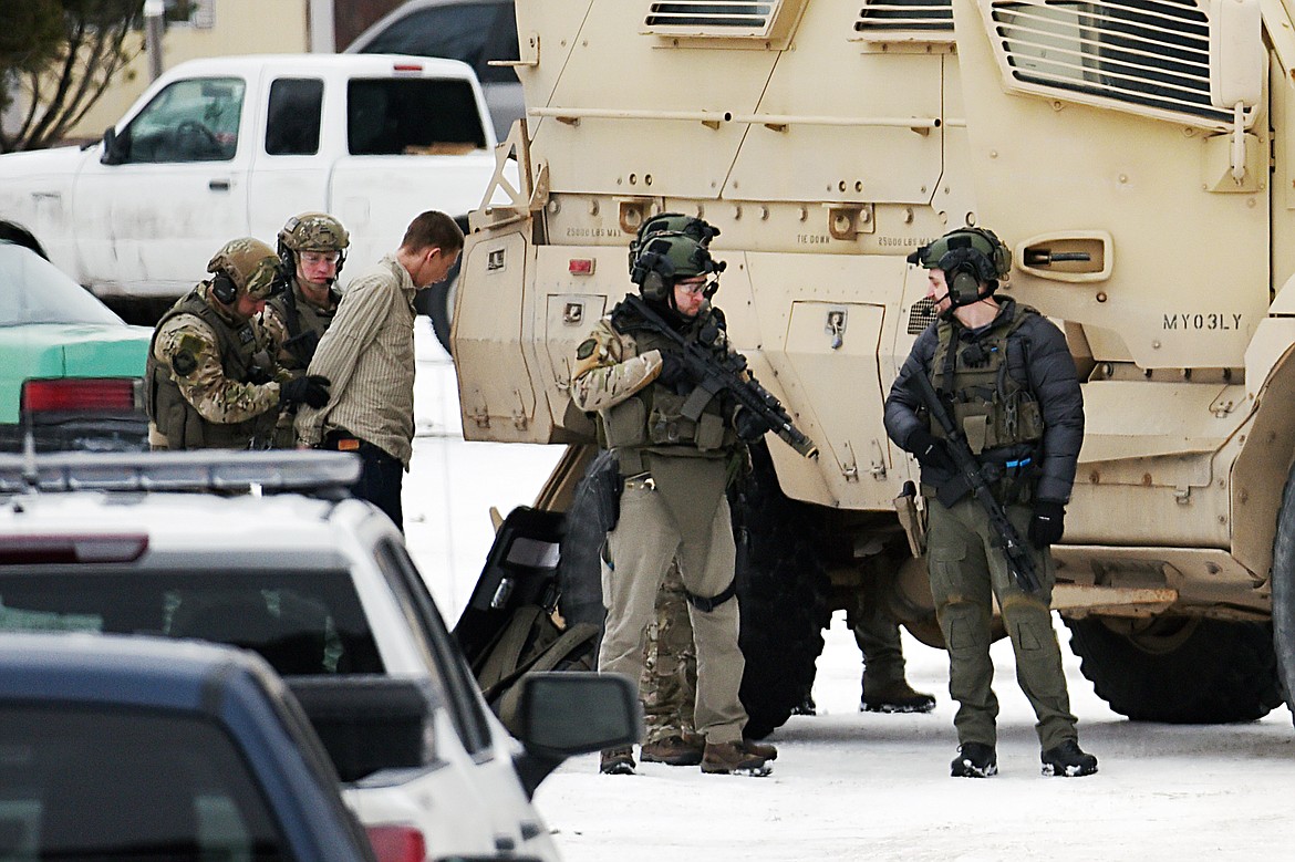 SWAT team members take a suspect into custody involved in a standoff in a mobile home park off Whitefish Stage Road in Kalispell on Wednesday. (Casey Kreider/Daily Inter Lake)