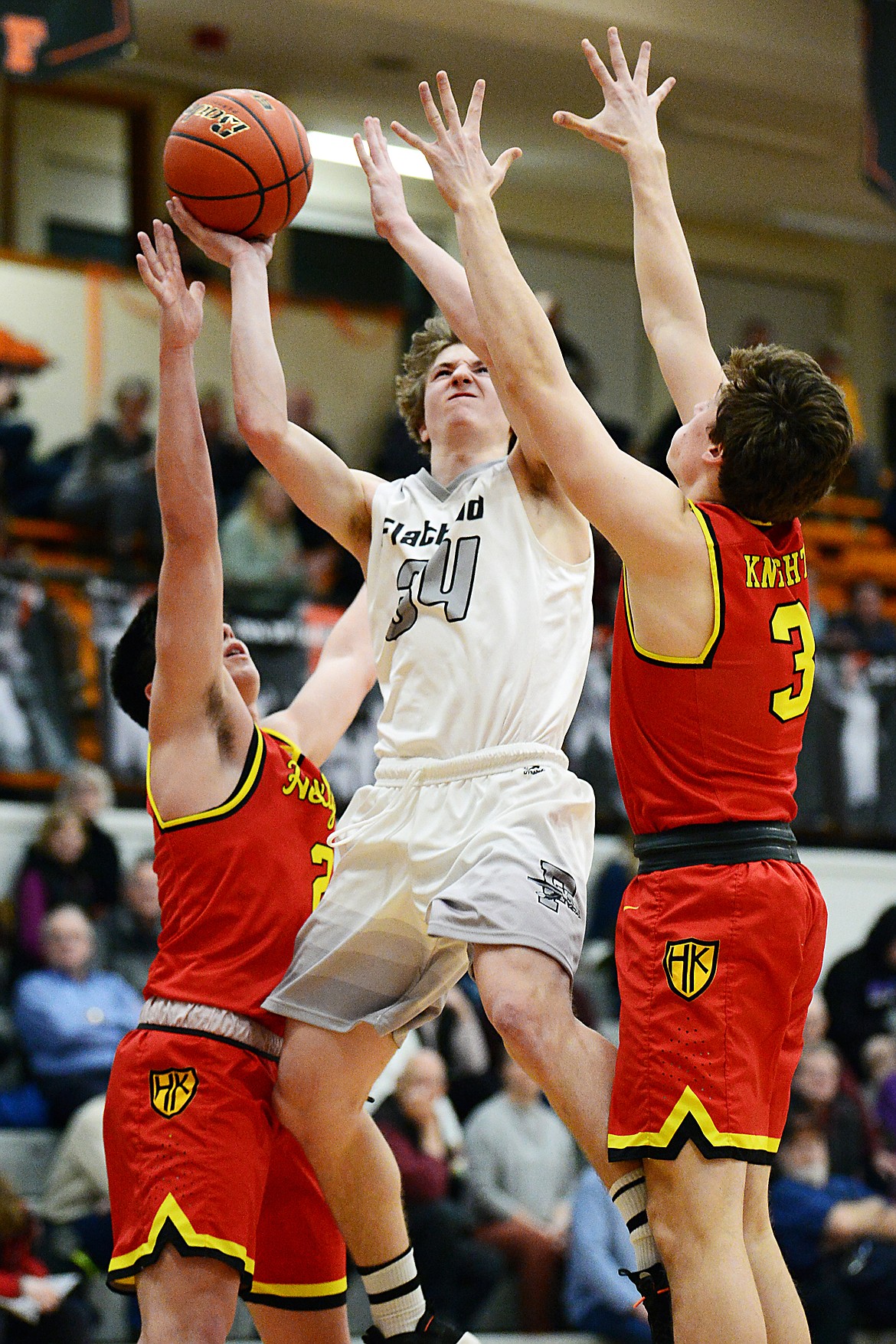 Flathead's Joston Cripe (34) drives to the hoop between Missoula Hellgate's Cam LaRance (2) and Wes Salonen (3) at Flathead High School on Tuesday. (Casey Kreider/Daily Inter Lake)