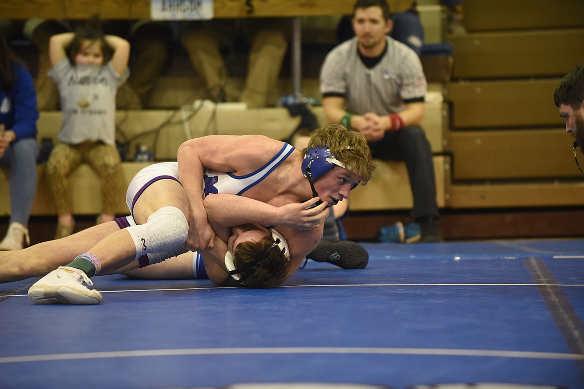 Mission-Charlo wrestler Isaiah Allik watches for the official to slap the mat marking his pin of Thompson Falls&#146; Dane Chojnacky in the finals of the 170-pound class of the Western B-C District tournament last Saturday in St. Ignatius. (Scott Shindledecker/Lake County Leader)