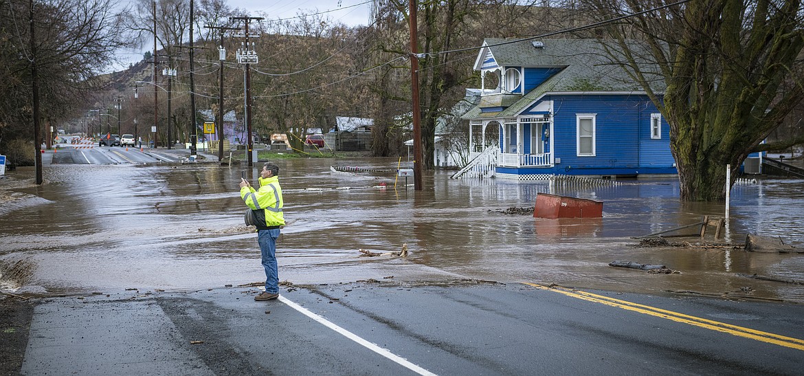 By Greg Lehman/Walla Walla Union-Bulletin via AP/
Touchet River water flows across Highway 12, closing it, on the east side of Waitsburg, Washington, on Friday, Feb. 7, 2020.