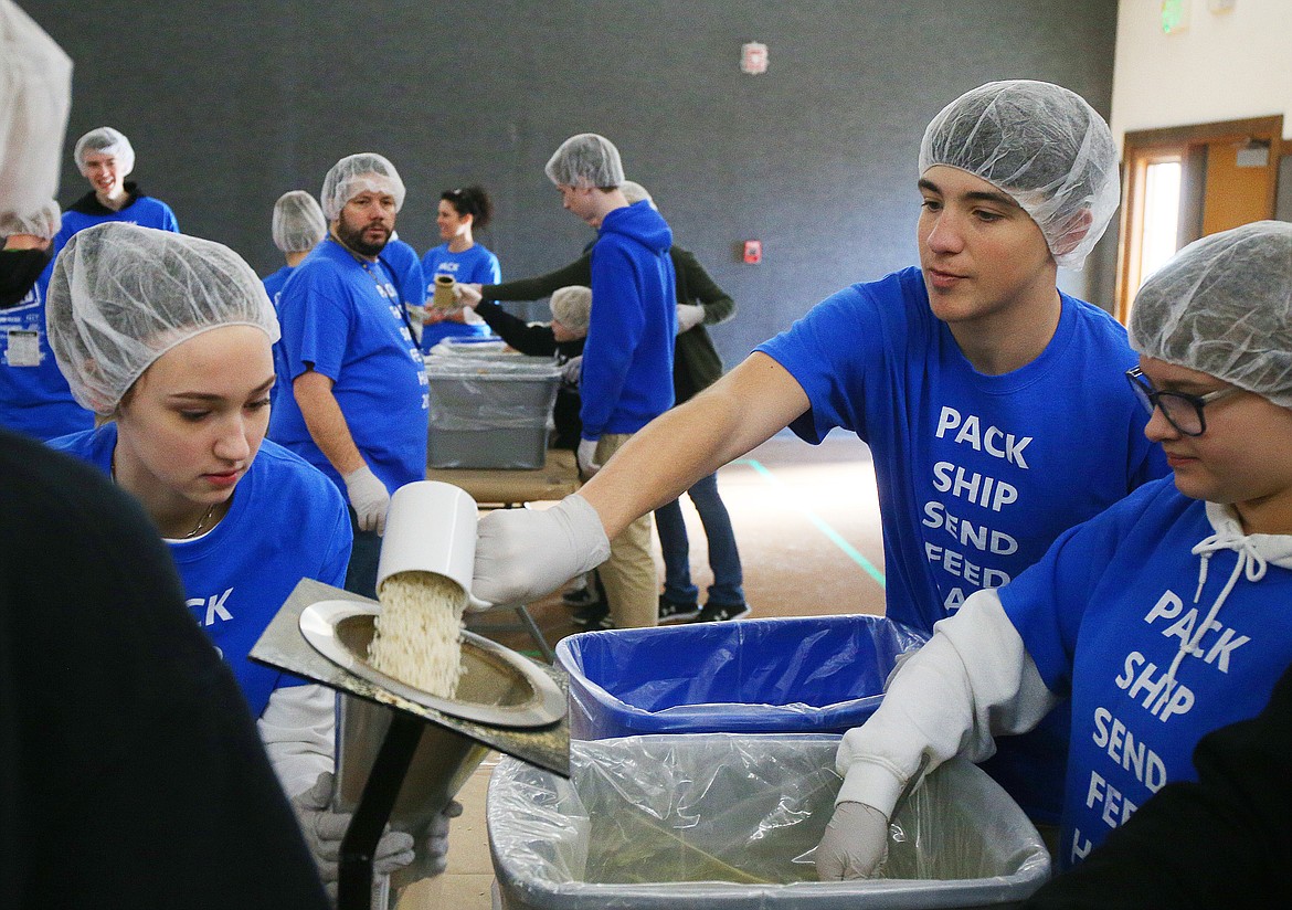 LOREN BENOIT/Press
Sophomore Caden Scott pours a serving of rice into a funnel during a Feed the Need packing party at North Idaho Christian School on Thursday. Feed the Need is a global organization through which schools can participate in service projects to help those in need around the world.