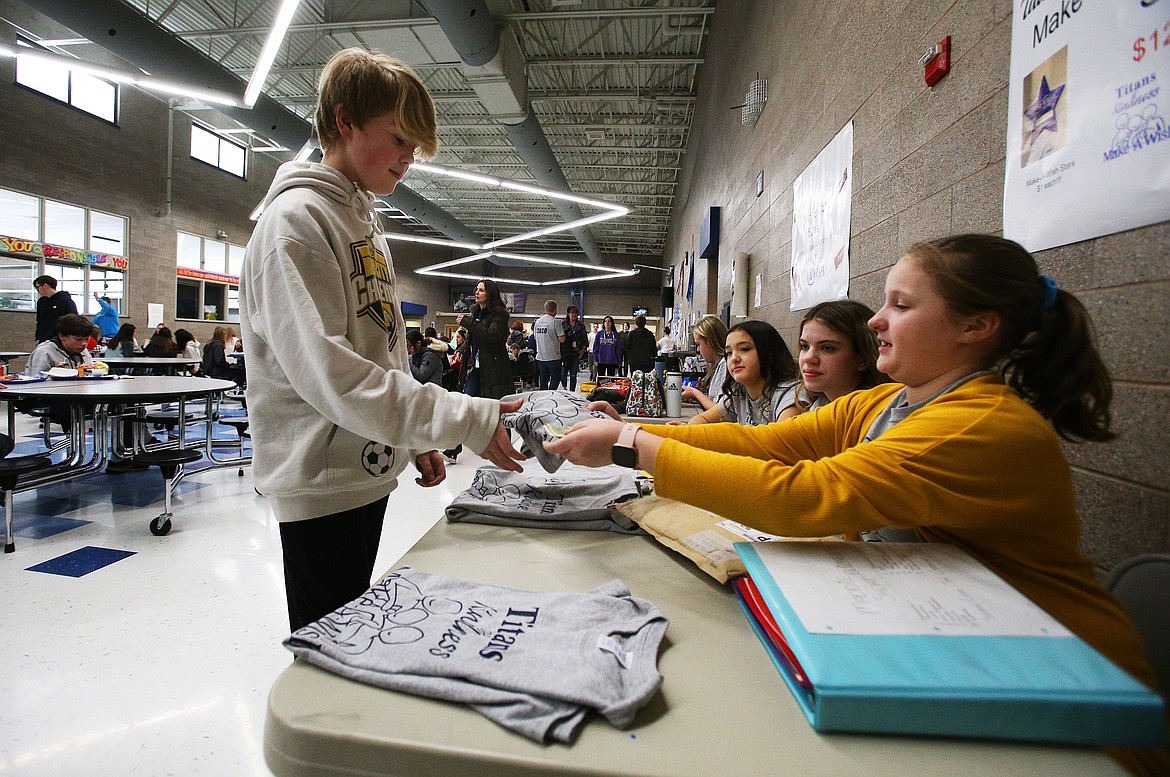 LOREN BENOIT/Press
Eighth grade student Carson Sullivan donates $12 to Make-A-Wish and gets a T-shirt from seventh grade ASB vice president Maddie Short during River City Middle School&#146;s Kindness Week.