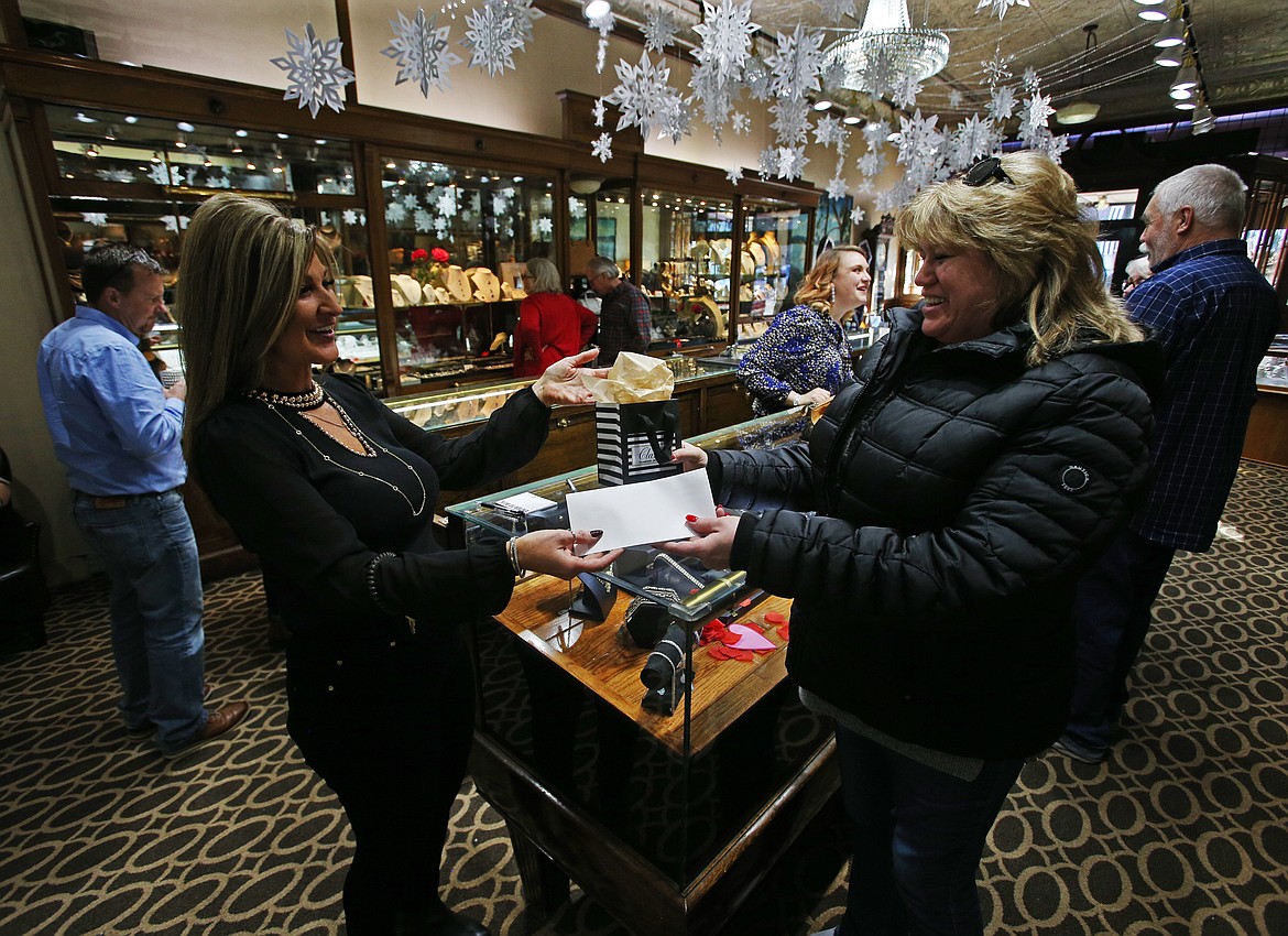 Kimberly Wickham, manager of Clark&#146;s Diamond Jewelers,  gifts a refund and a gift bag to customer Lori Hood, who bought a ring during Clark's Let it Snow promotion between Nov. 22 and Dec. 31. (LOREN BENOIT/Press)