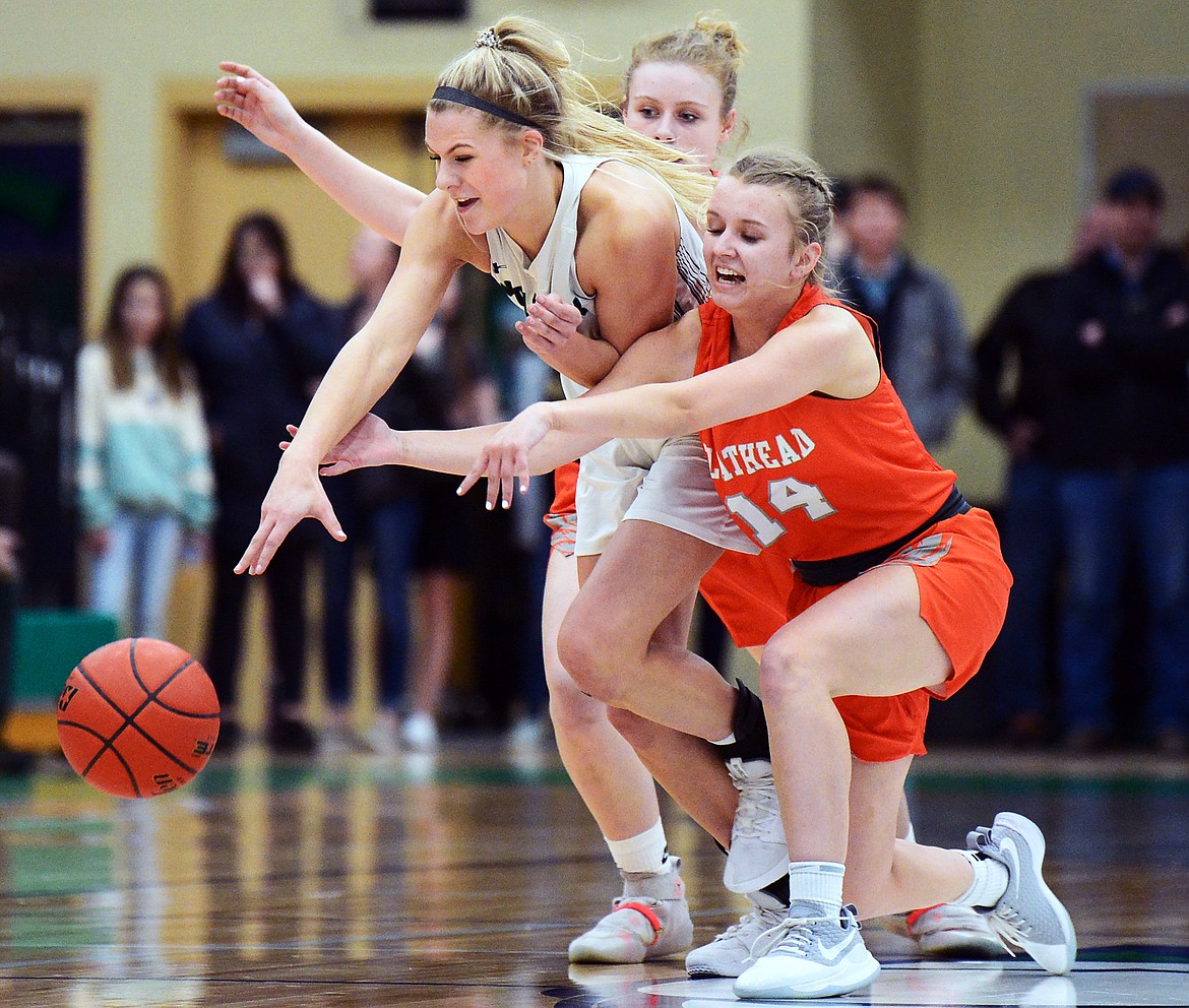 Glacier's Aubrie Rademacher (14) fights for a loose ball with Flathead's Molly Winters (34) and Jenna Johnson (14) during a crosstown matchup at Glacier High School on Friday. (Casey Kreider/Daily Inter Lake)