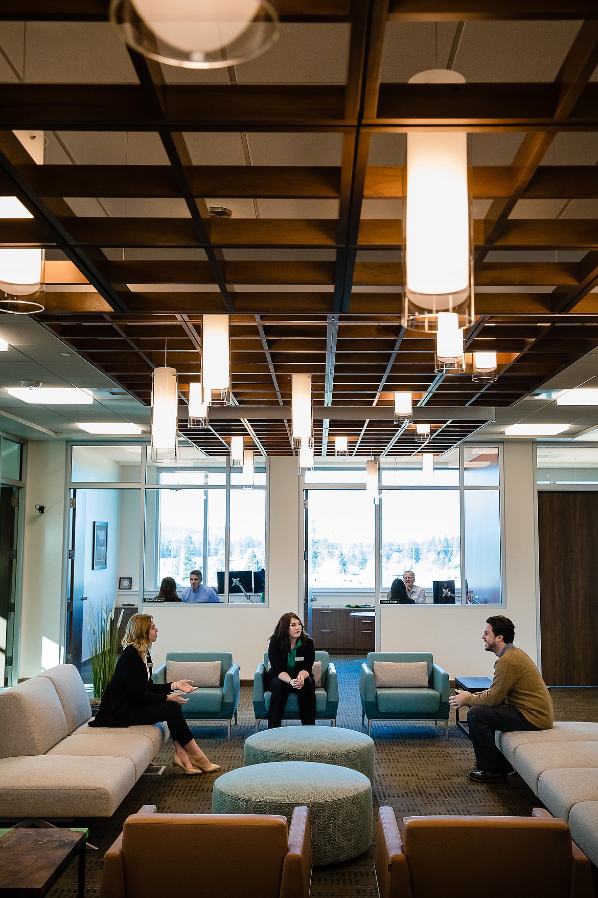 ICCU member service specialists Kacie Dean and Kelsey Mapston talk with Dylan Pearson, an ICCU construction loan officer, on the third-floor of the credit union&#146;s new branch in Coeur d&#146;Alene.