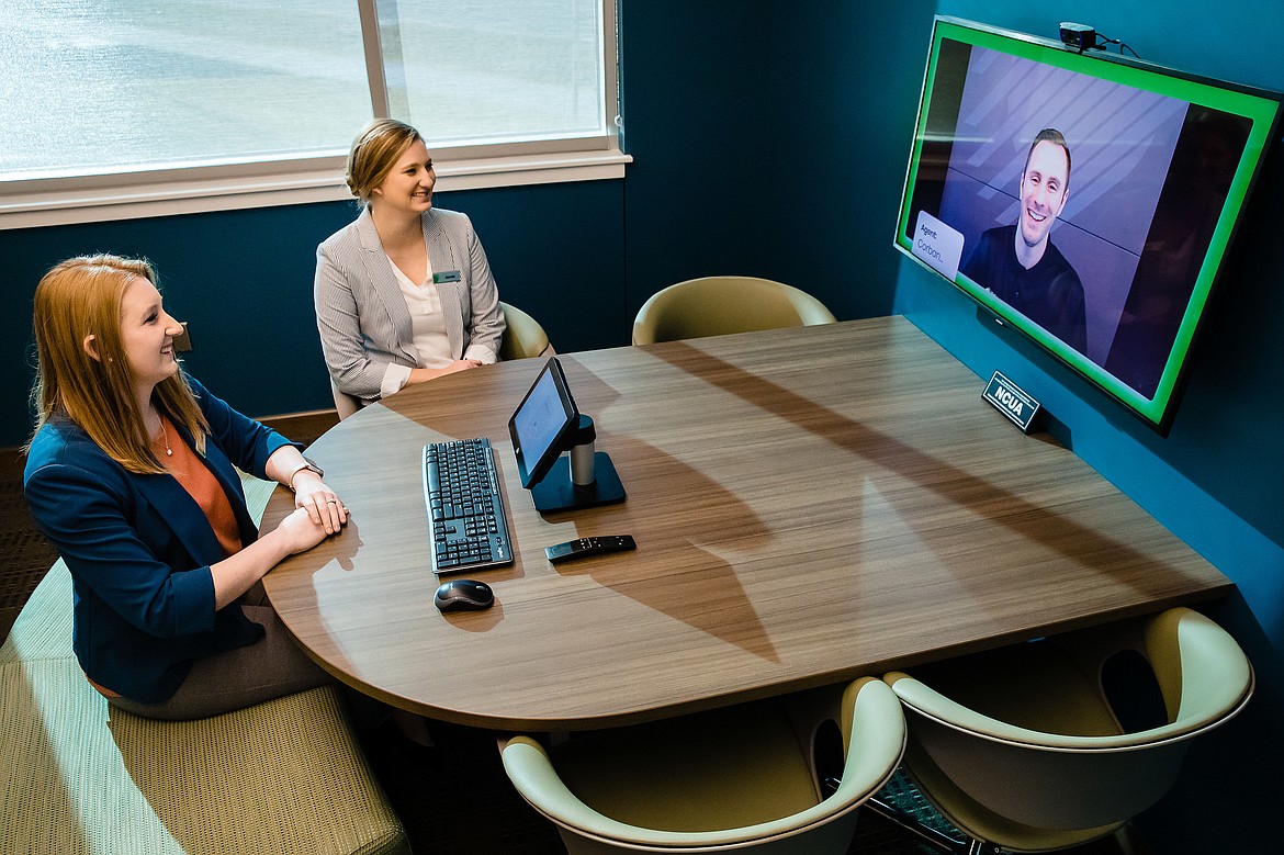 KaitLyn Osborn, left, assistant branch manager, and Jamie Roderick, a financial service officer, hold a video conference with Corban Latimore, a visual service center agent, in the branch&#146;s video service center. The technology space offers members the ability to discuss various banking services when all other member service specialists at the branch are assisting other members.