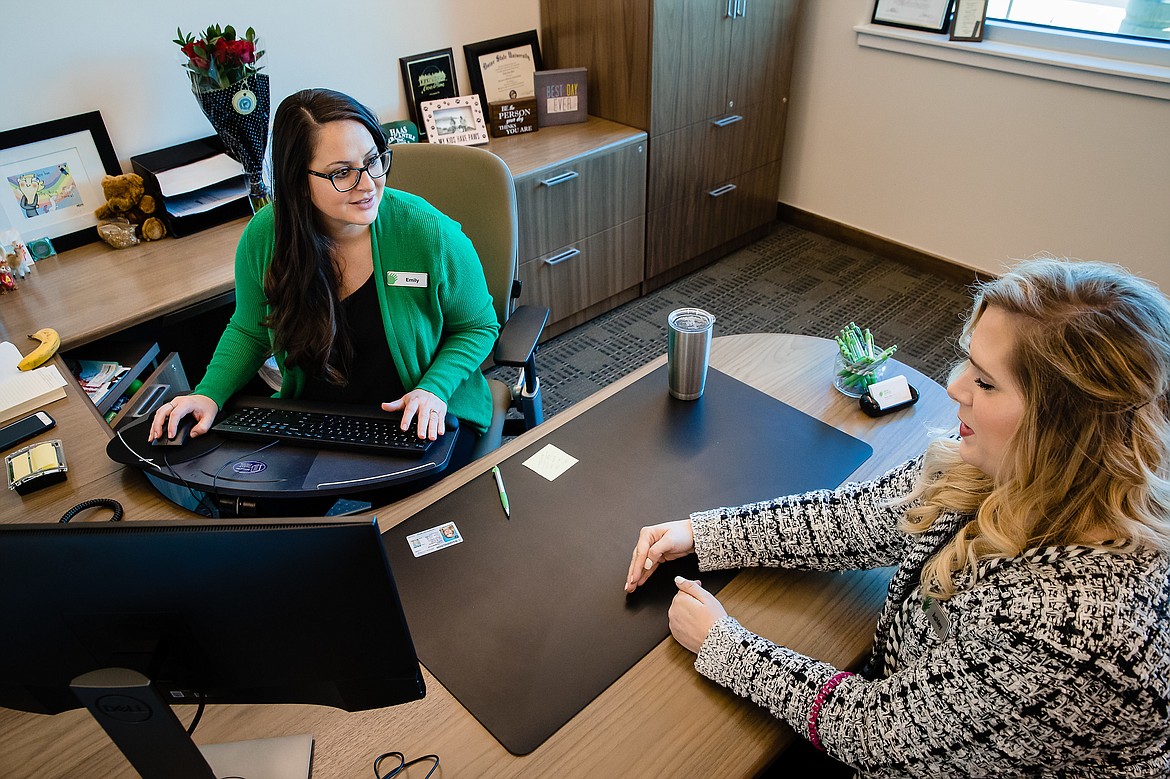 Emily Haas, the branch manager of ICCU&#146;s newest location in Coeur d&#146;Alene, assists Ashley Tolman, a member service specialist, with a new account.