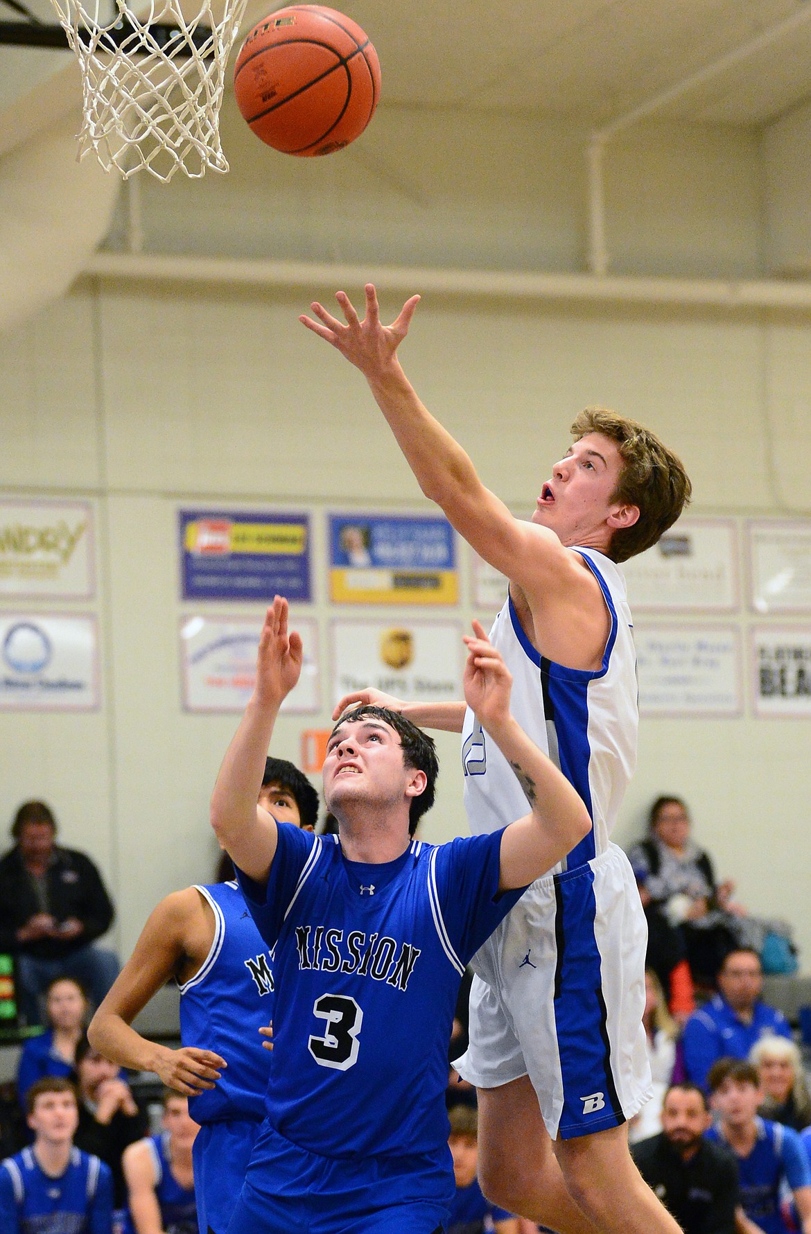 Bigfork's Bryce Gilliard (15) grabs a rebound for a putback over Mission's Kolten Gardipe (3) at Bigfork High School on Thursday. (Casey Kreider/Daily Inter Lake)