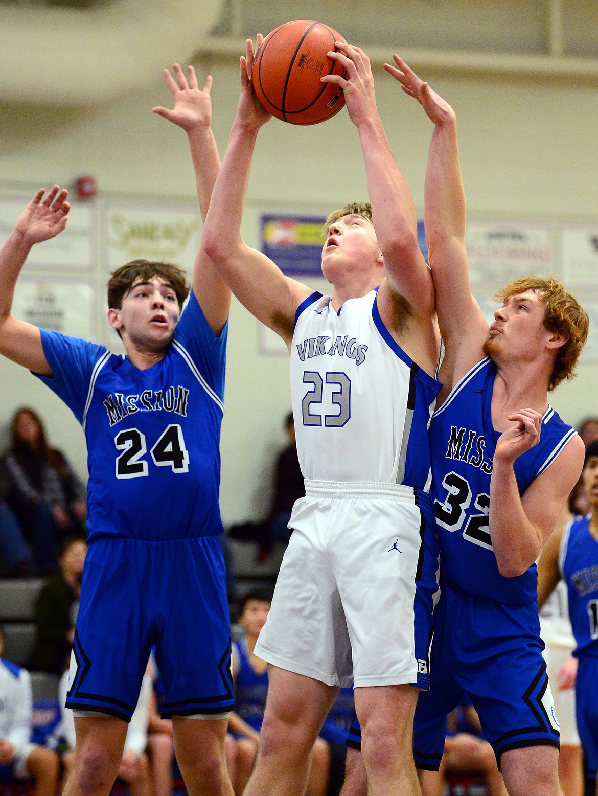 Bigfork's Isaac Bjorge (23) looks to shoot between Mission's Jedi Christy (24) and Layne Spidel (32) at Bigfork High School on Thursday. (Casey Kreider/Daily Inter Lake)