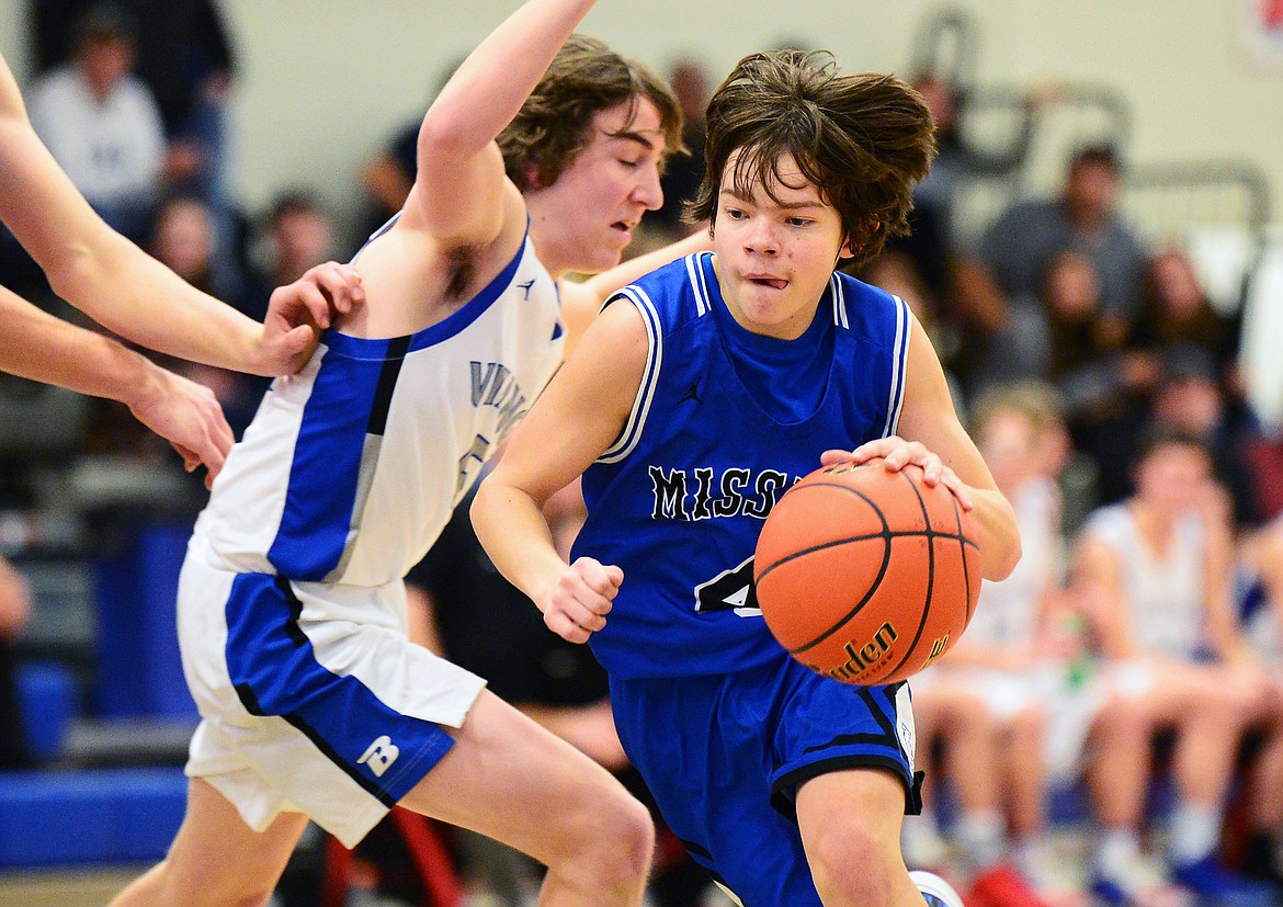 Mission's Zoran LaFrombois (4) drives to the hoop against Bigfork's Walker Fisher (5) at Bigfork High School on Thursday. (Casey Kreider/Daily Inter Lake)