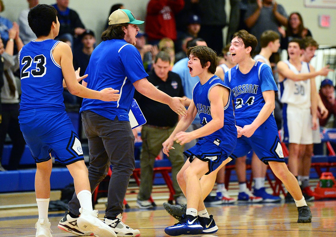 Mission's Davien Adams (23), Zoran LaFrombois (4) and Jedi Christy (24) celebrate after the Bulldogs' 47-44 win over Bigfork at Bigfork High School on Thursday. (Casey Kreider/Daily Inter Lake)