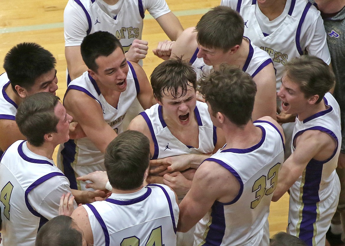 Polson players mob freshman Jarrett Wilson after he led the Pirates with 4 steals and 10 points in the final 2 minutes of the game agains Libby Saturday night in Pablo. (Bob Gunderson photo)