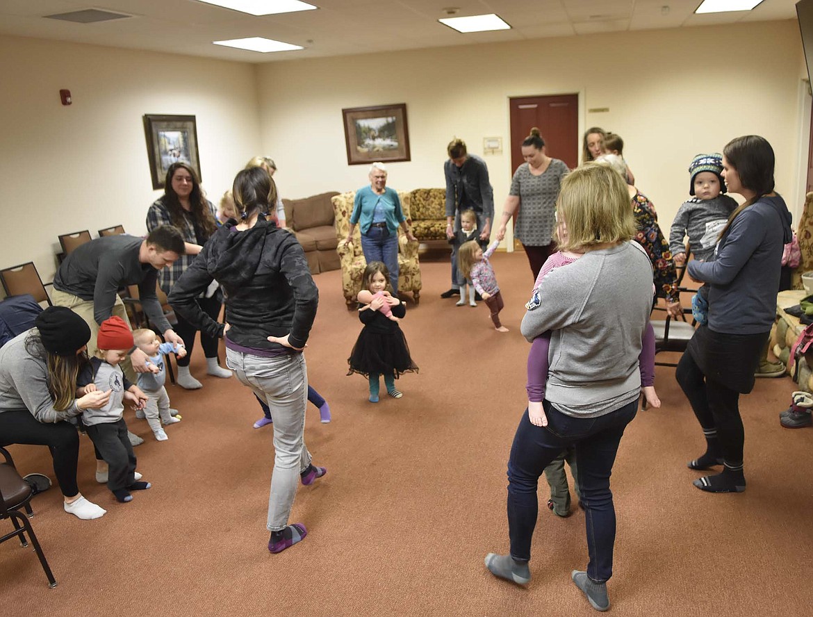 Children and adults dance together to music during North Valley Music School&#146;s Music Together class at The Springs at Whitefish on Wednesday afternoon. Residents of the Springs are invited to join in on the class designed to introduce young children to music. (Heidi Desch/Whitefish Pilot)