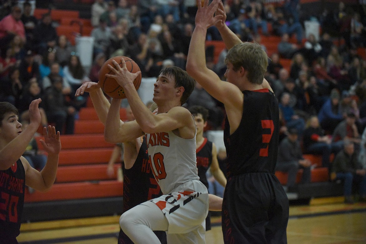 Plains guard Treydon Brouillette gets between Hot Springs defenders Lincoln Slonaker (2), Jack McAllister (3) and Brandon Knudsen (20) for a shot attempt during Friday&#146;s 14-C District tournament in Ronan. Plains beat the Savage Heat, 70-46, and St. Regis, 55-45, Saturday to claim the title. (Scott Shindledecker/Valley Press)