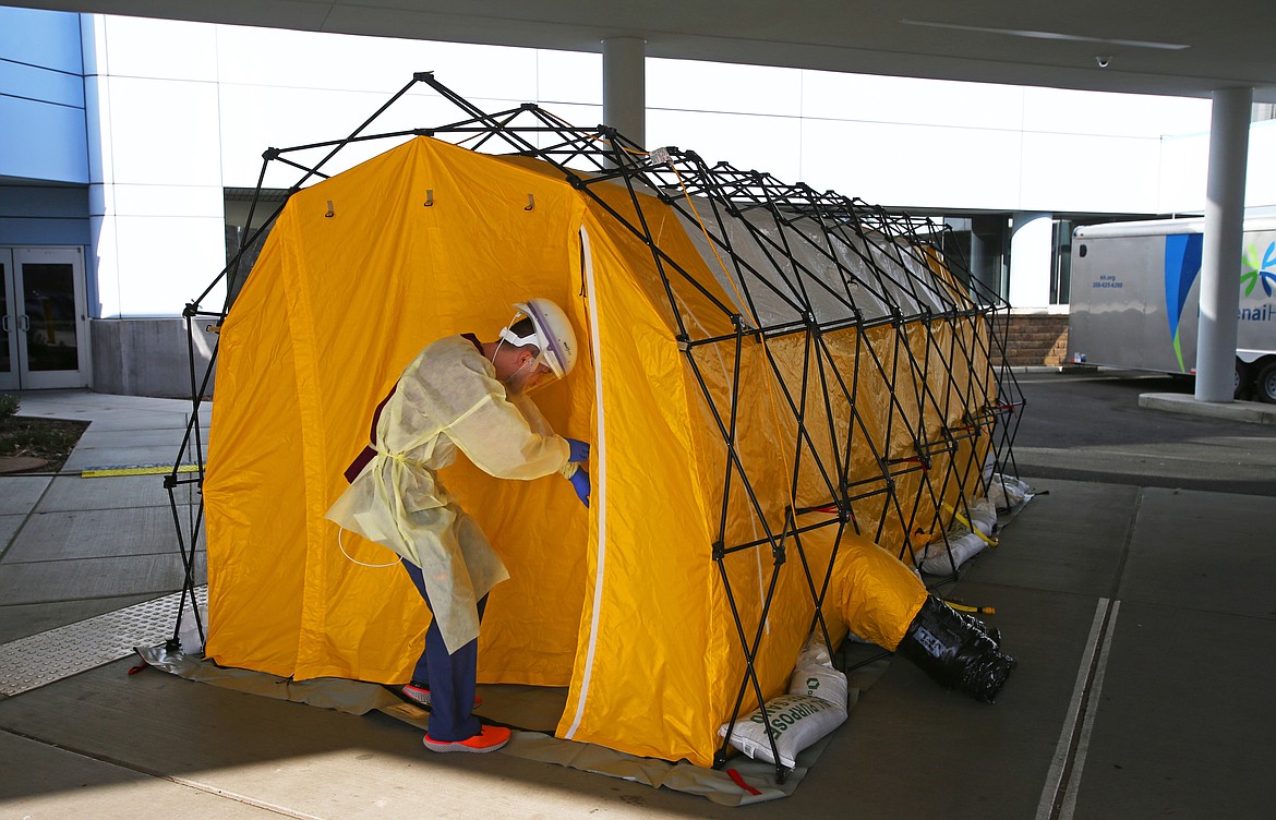 LOREN BENOIT/Press
Kootenai Health technician Adam Garman enters a tent outside the emergency department entrance to the hospital Wednesday. The tent allows emergency staff to test people for COVID-19 without the risk of infecting other people inside the hospital.