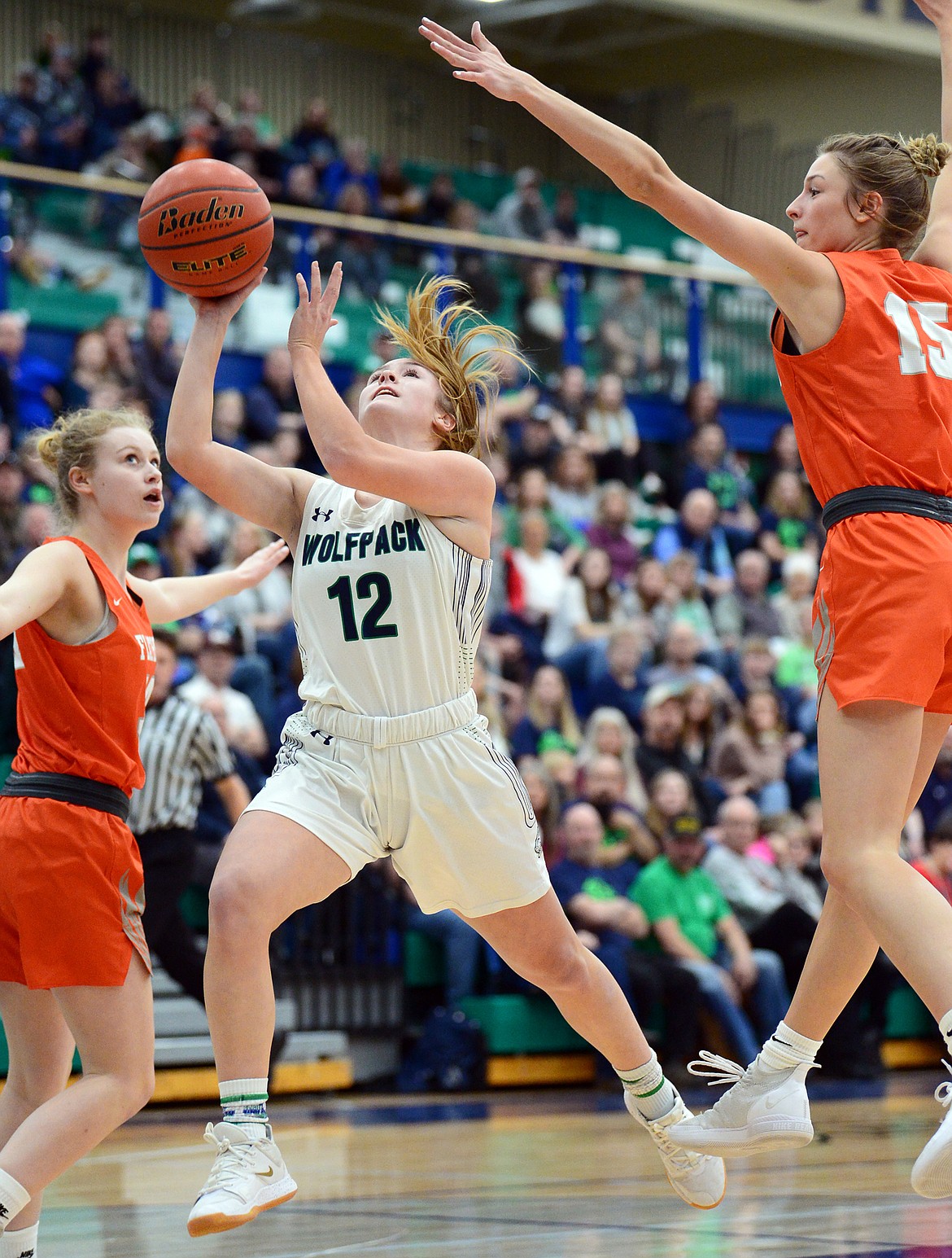 Glacier's Kenzie Williams (12) drives to the basket between Flathead's Molly Winters (34) and Clare Converse (15) during a crosstown matchup at Glacier High School on Friday. (Casey Kreider/Daily Inter Lake)