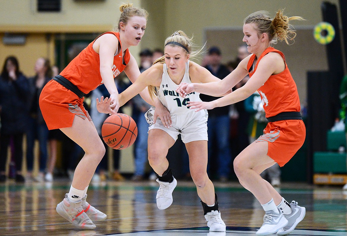 Glacier's Aubrie Rademacher (14) fights for a loose ball with Flathead's Molly Winters (34) and Jenna Johnson (14) during a crosstown matchup at Glacier High School on Friday. (Casey Kreider/Daily Inter Lake)