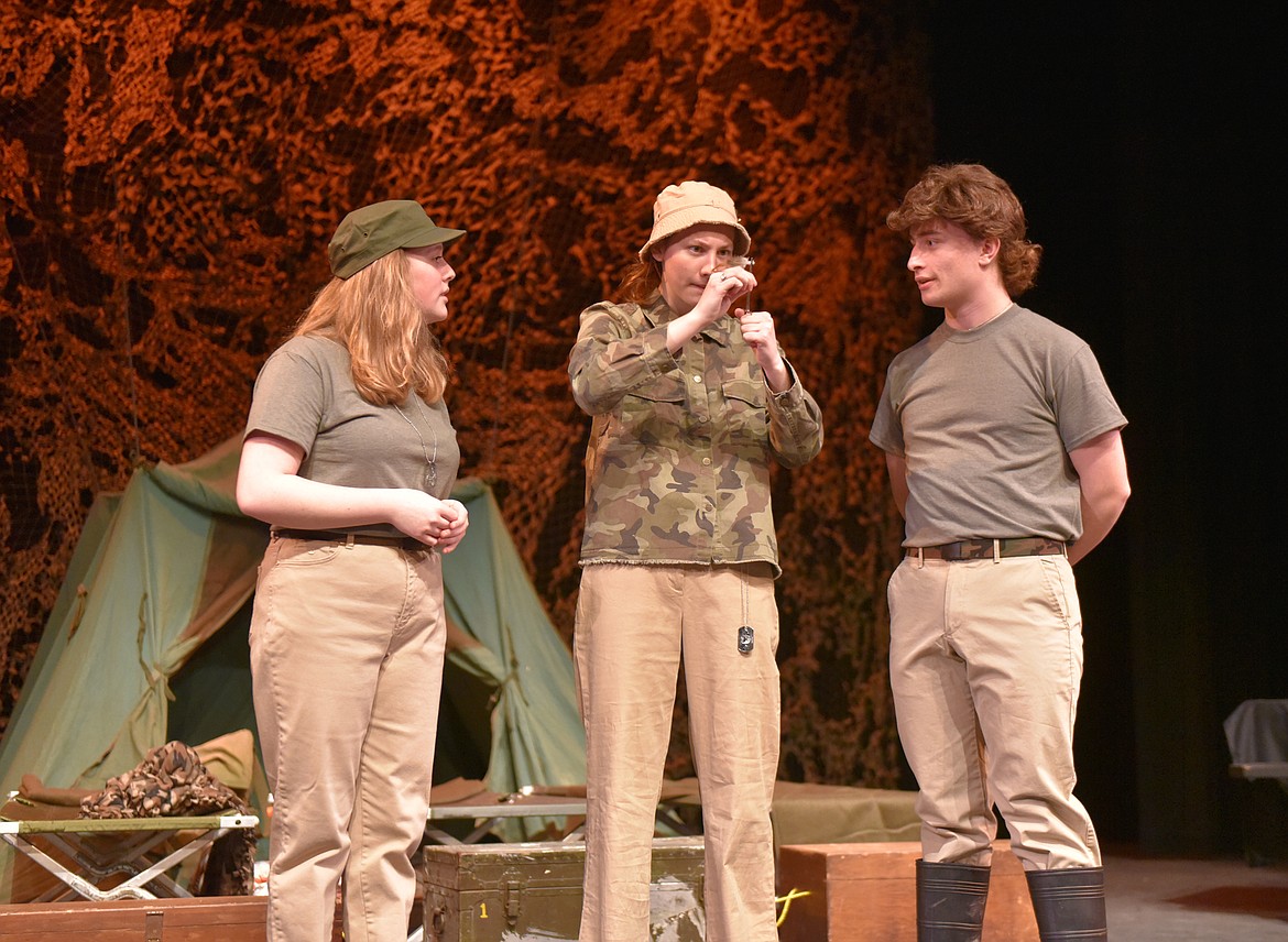 Lucy Schindler, as Major Margaret Houlihan, left, and Luca Welle, as Major Frank Burns, right, discuss concerns with the Army unit while Eden Scrafford, as Lt. Colonel Henry Blake, ties a fishing fly during a rehearsal for &#147;MASH&#148; at the Whitefish Performing Arts Center. The Whitefish High School Drama Club brings the play to the stage on March 5, 6 and 7. (Heidi Desch/Whitefish Pilot)